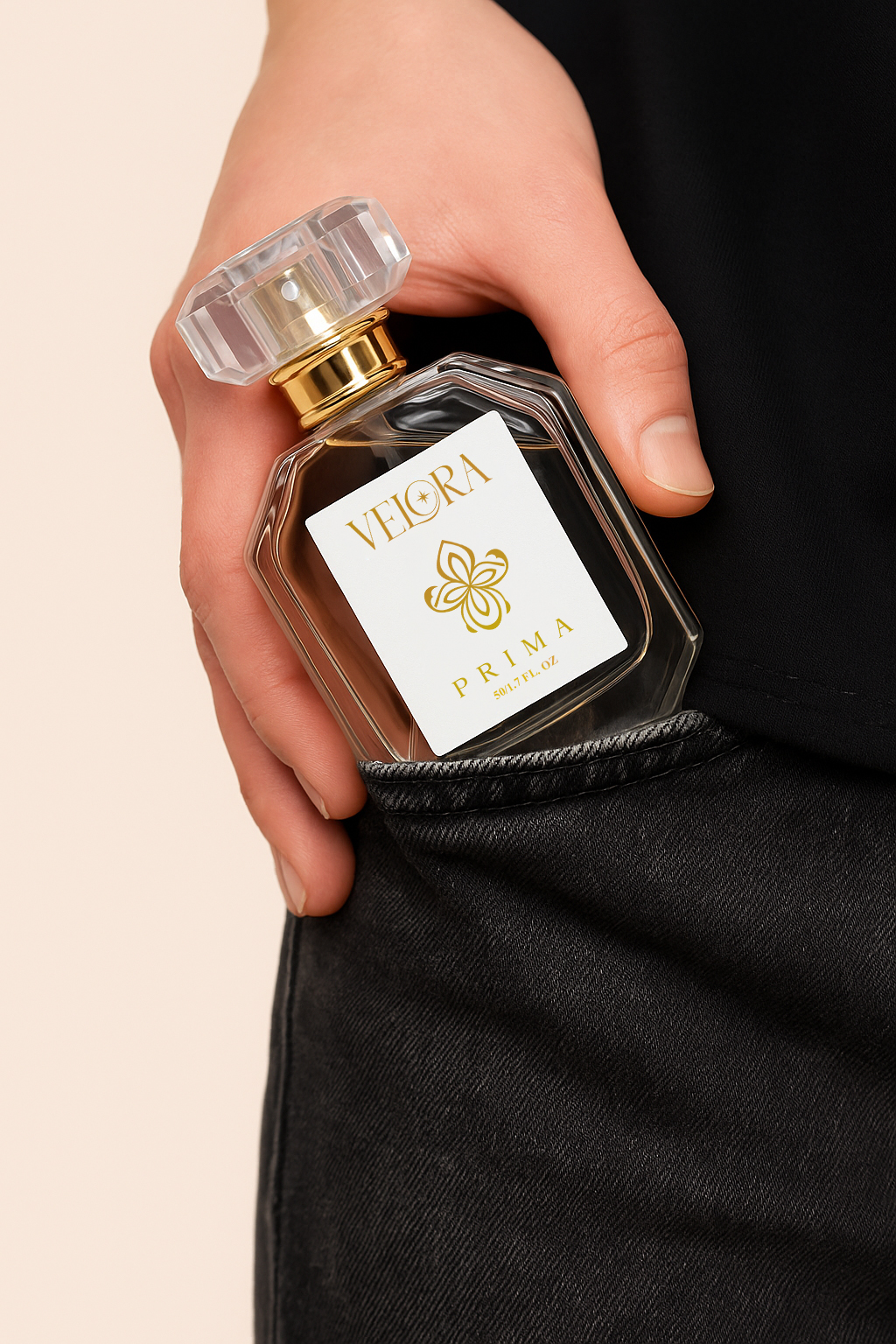 Hand placing Velora Prima luxury eau de parfum bottle into black denim pocket, showcasing elegant glass perfume design with gold logo.