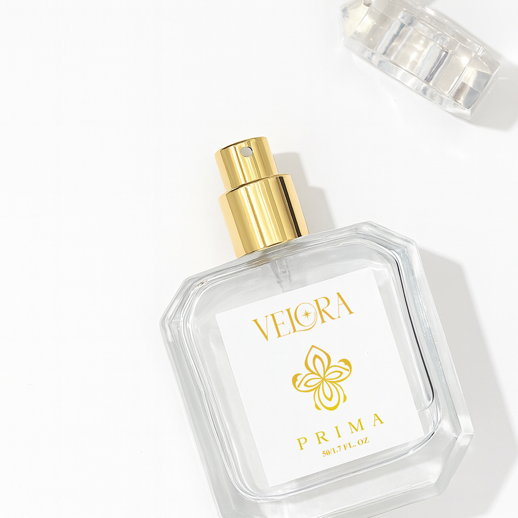Velora Prima luxury eau de parfum bottle with gold spray nozzle and clear glass design, photographed on white background with cap removed.