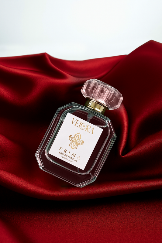 Velora Prima eau de parfum bottle on rich red silk fabric